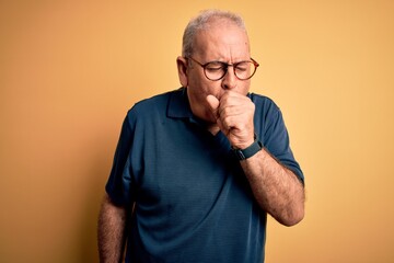 Middle age handsome hoary man wearing casual polo and glasses over yellow background feeling unwell...