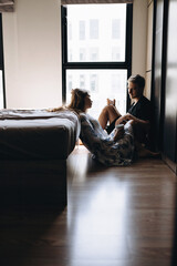 A man and a girl are sitting on the floor with masks on their faces