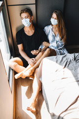 A man and a girl are sitting on the floor with masks on their faces