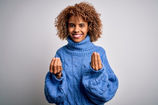 Young beautiful african american woman wearing turtleneck sweater over white background doing money gesture with hands, asking for salary payment, millionaire business