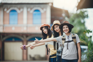 Asian woman group backpacker wearing hat, Young female hitchhiking on street, Friendship traveller backpack travel for new experience. Happy young girl group tourist. - Powered by Adobe