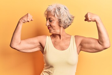 Senior grey-haired woman wearing casual clothes showing arms muscles smiling proud. fitness concept. - obrazy, fototapety, plakaty