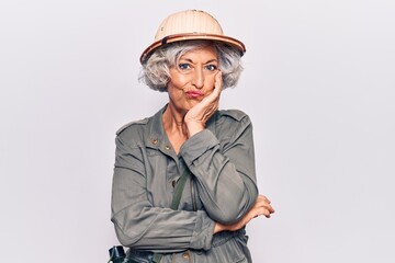 Senior grey-haired woman wearing explorer hat thinking looking tired and bored with depression problems with crossed arms.