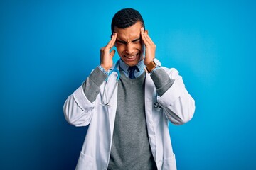 Handsome african american doctor man wearing coat and stethoscope over blue background with hand on headache because stress. Suffering migraine.