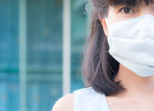 Corona virus covid-19 with Close up asia woman wearing protective mask on blur image of blue background.