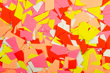 Abstract background texture of multi-colored paper cut into small pieces on the surface