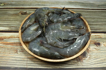 Pile of fresh shrimp on the wooden plate. Famous seafood ingredient in Asia kitchen. Mock up of raw material in the fresh market. 