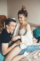 Lovely caucasian couple embracing and playing in bed while smile