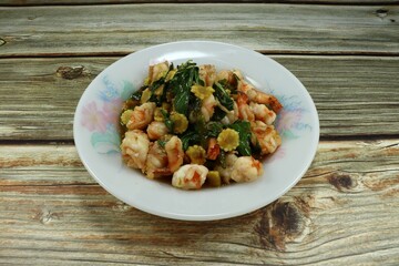 Fried spicy shrimp with basil and chilly on the plate. Famous hot and spicy street food in Asia. 