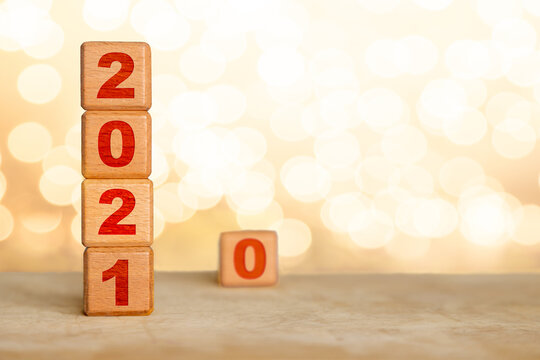Welcoming New Year 2021 wood cube blocks and concept of leaving 2020 behind, a year to be forgotten