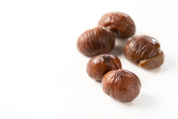 Peeled sweet chestnuts on a white background