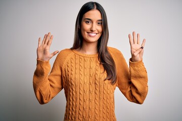 Young beautiful brunette woman wearing casual sweater over isolated white background showing and...