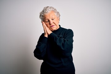 Senior beautiful woman wearing casual black sweater standing over isolated white background sleeping tired dreaming and posing with hands together while smiling with closed eyes.