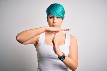 Young beautiful woman with blue fashion hair wearing casual t-shirt over white background Doing...