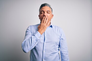 Middle age handsome grey-haired business man wearing elegant shirt over white background bored yawning tired covering mouth with hand. Restless and sleepiness.