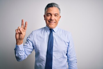 Middle age handsome grey-haired business man wearing elegant shirt and tie smiling looking to the camera showing fingers doing victory sign. Number two.
