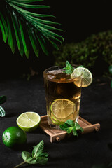 Cold black tea with fresh lime on dark background