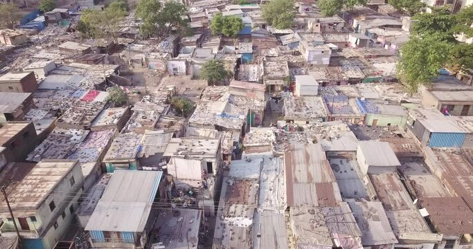 Aerial fly over above the roftops of self-builted houses of the Slum in the inner city of Pune, Maharashtra, India.