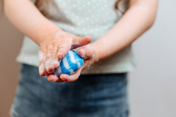 Children's hands in soapy foam.