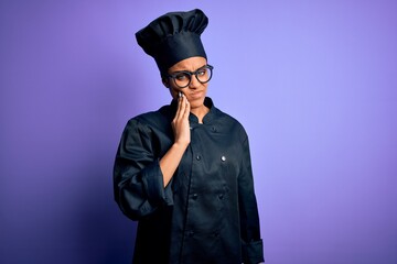 Young african american chef girl wearing cooker uniform and hat over purple background touching mouth with hand with painful expression because of toothache or dental illness on teeth. Dentist