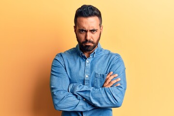 Young hispanic man wearing casual clothes skeptic and nervous, disapproving expression on face with crossed arms. negative person.