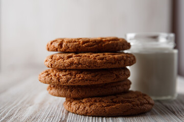 Tasty cookies and a glass of milk in a transparent glass on a white background