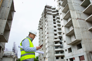  Construction Engineer discussion on phone with Architect at Construction Site