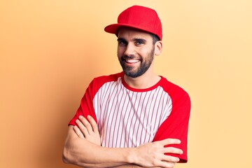 Young handsome man with beard wearing baseball cap and t-shirt happy face smiling with crossed arms looking at the camera. positive person.