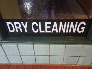 black and white dry cleaning sign on store window with a lot of water
