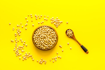 soy beans in bowl on yellow desk top-down