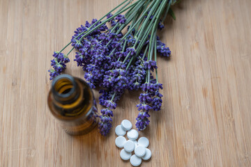 Fototapeta na wymiar Flasche mit Pillen Hintergrund mit Lavendel als Heilmedizin