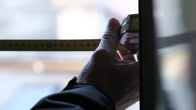 person taking measurement for a window installation