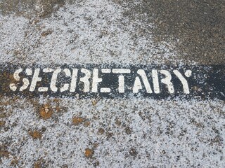 secretary sign on black asphalt with white snow