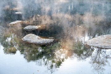 Fototapeta na wymiar Beautiful morning fog or smoke over Huay mak leam hot spring, Lam Nam Kok National Park, Thailand
