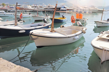 Seaport. Boats moored to the pier in the azure water. Empty Wharf.