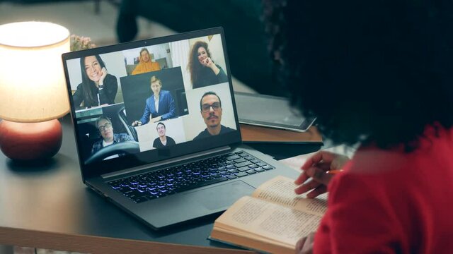 Videocall, video conference concept. A girl talks to people via laptop amid pandemic.