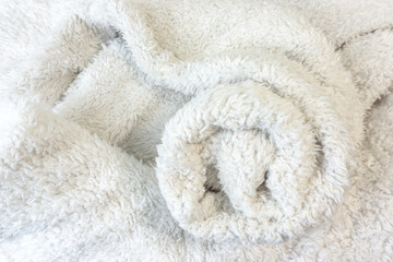 Fototapeta na wymiar A top view of white half folded in roll of fluffy fur fabric look soft and clean.