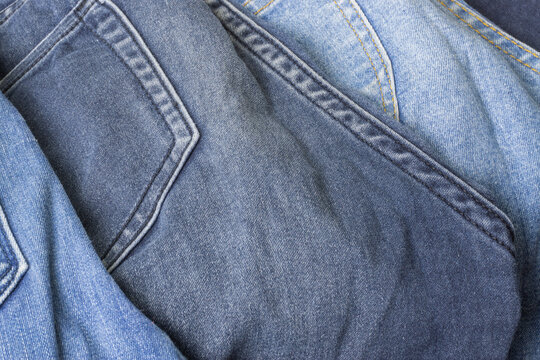 Close up of grey geans in a pile of blue jeans.
