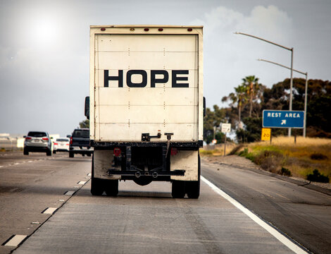 Truck driving down the freeway with HOPE written in large black letters on the back