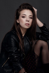 Naklejka premium fashion model woman in a black jacket on a gray background