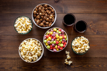 Popcorn and soda - cinema snacks - on wooden table top-down