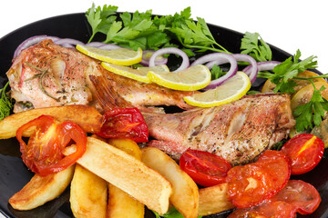 Baked ocean perches with tomatoes and fried potatoes, fragment closeup