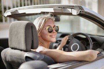 Blonde woman with sunglasses driving a car