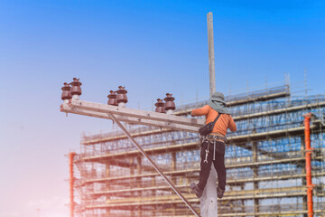 Naklejka premium Worker on the height wear safety harness, Electric lineman repairman worker at climbing work on electric post power pole in construction site on structure steel background.