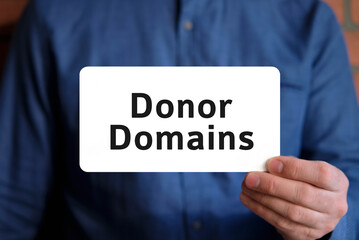 Donor domains text on a white sign in the hand of a man in a blue shirt