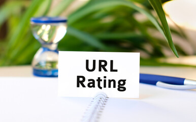 Url rating seo business concept text on a white notebook and hourglass, blue pen, green flowers