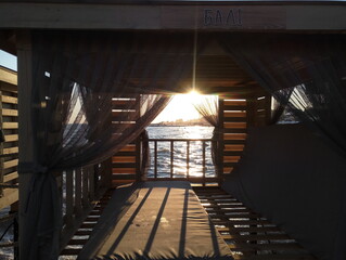 sunset at sea through the gazebo on the beach