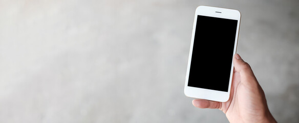 Mock up smartphone of hand holding black mobile phone with blank white screen.