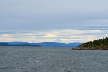 Typical Swedish nature and houses on the shore of the fjord. View from the high bridge over the fjord. The border of Norway and Sweden.Near the town Selater,Sweden