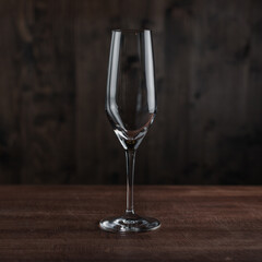 Empty champagne glass on wooden table against dark background in bar. Catering Concept